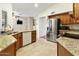 Bright eat-in kitchen with wood cabinets, stainless steel appliances, granite countertops, and tile floors at 20215 N Medallion Ct, Sun City West, AZ 85375