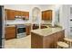 Well-lit kitchen featuring stainless steel appliances, tile floors, wood cabinetry and granite countertops at 20215 N Medallion Ct, Sun City West, AZ 85375