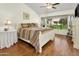Bright main bedroom with hardwood floors, vaulted ceiling, and a large window overlooking backyard at 20215 N Medallion Ct, Sun City West, AZ 85375