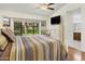 Bright main bedroom with hardwood floors, vaulted ceiling, and a large window overlooking backyard at 20215 N Medallion Ct, Sun City West, AZ 85375