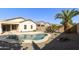 Serene backyard oasis featuring a sparkling pool, mature palm trees, and desert landscaping at 41201 N Stenson Dr, San Tan Valley, AZ 85140