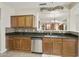 Well-appointed kitchen with granite countertops, a stainless steel dishwasher, and wood cabinets for a modern and inviting feel at 41201 N Stenson Dr, San Tan Valley, AZ 85140