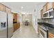 Bright kitchen showcasing stainless steel appliances, granite countertops, and tile flooring for a modern and clean aesthetic at 41201 N Stenson Dr, San Tan Valley, AZ 85140