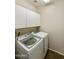 Bright laundry room with white cabinets and modern Samsung washer and dryer at 41201 N Stenson Dr, San Tan Valley, AZ 85140