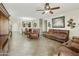 Spacious living room featuring a ceiling fan and comfortable brown leather furniture, perfect for relaxation and gatherings at 41201 N Stenson Dr, San Tan Valley, AZ 85140