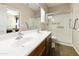 Well-lit main bathroom with a double sink vanity, a glass-enclosed shower, and neutral walls at 41201 N Stenson Dr, San Tan Valley, AZ 85140