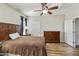 Cozy main bedroom featuring warm tones, natural light, a ceiling fan, and a full closet for ample storage at 41201 N Stenson Dr, San Tan Valley, AZ 85140