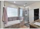 Bright bathroom featuring a separate tub, shower, and tile surround at 5255 W Cochise Dr, Glendale, AZ 85302