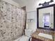 Bathroom featuring a shower with floral curtain, toilet, and vanity with granite counters and dark brown cabinets at 5255 W Cochise Dr, Glendale, AZ 85302