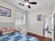 This bedroom features a ceiling fan, a large window and wood flooring at 5255 W Cochise Dr, Glendale, AZ 85302