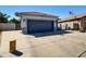 Exterior view of the home with a driveway, two-car garage, and low maintenance landscaping at 5255 W Cochise Dr, Glendale, AZ 85302