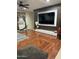 Cozy living room with hardwood floors, decorative wall, and a large TV at 5255 W Cochise Dr, Glendale, AZ 85302