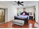 Spacious main bedroom featuring hardwood floors, ceiling fan, and dark wood furniture at 5255 W Cochise Dr, Glendale, AZ 85302
