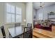 Elegant dining area with dark wood table and chairs, open to a living room, and a large window with plantation shutters at 615 E Portland St # 160, Phoenix, AZ 85004