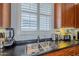 A kitchen boasts a stainless steel sink and black countertop with wooden cabinets and appliances at 615 E Portland St # 160, Phoenix, AZ 85004