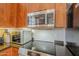 Kitchen features stainless steel microwave above an electric stovetop and warm wood cabinetry at 615 E Portland St # 160, Phoenix, AZ 85004