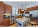Contemporary kitchen with stainless steel appliances, dark cabinets, eat-in island, and hardwood flooring at 615 E Portland St # 160, Phoenix, AZ 85004