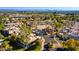 Wide aerial shot of a community with pool, tennis courts, mature trees, and city skyline in the distance at 6229 N 30Th Way, Phoenix, AZ 85016