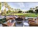 Outdoor lounge area with comfortable seating around a fire pit, set against a backdrop of lush greenery and palm trees at 6229 N 30Th Way, Phoenix, AZ 85016