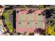 Aerial view of well-maintained tennis courts with professional lighting, surrounded by lush landscaping and palm trees at 6229 N 30Th Way, Phoenix, AZ 85016