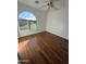 Sunlit bedroom with a view from the arched window and beautiful wood flooring at 6416 N 78Th Ln, Glendale, AZ 85303