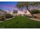 Lush green backyard with neatly trimmed grass and desert landscaping providing a serene outdoor space at 7501 E Phantom Way, Scottsdale, AZ 85255