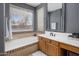Bright bathroom featuring a soaking tub with decorative tile surround and a vanity at 7501 E Phantom Way, Scottsdale, AZ 85255