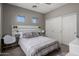 Cozy bedroom featuring two small windows, sliding closet, and stylish decor at 7501 E Phantom Way, Scottsdale, AZ 85255