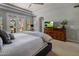 The main bedroom provides backyard views, ceiling fan, TV, and a charming dresser at 7501 E Phantom Way, Scottsdale, AZ 85255