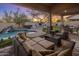 Outdoor living space featuring covered patio, outdoor kitchen, pool, and comfortable seating area at 7501 E Phantom Way, Scottsdale, AZ 85255
