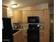 Eat-in kitchen features modern black appliances and light wood cabinets at 7807 E Main St # F24, Mesa, AZ 85207