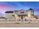 Two-story home with turret feature, well-lit walkway, and white picket fence in desert landscape at 10036 E Jensen St, Mesa, AZ 85207