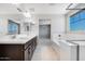 Well-lit bathroom with dual sinks, white countertops, sleek cabinetry, and a separate soaking tub at 12219 W Caraveo Pl, Peoria, AZ 85383
