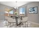 Bright dining area with modern table, stylish chairs, statement chandelier and sliding glass door to patio at 12219 W Caraveo Pl, Peoria, AZ 85383