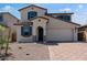 Charming two-story home featuring desert landscaping, an arched entryway, and a two-car garage at 12219 W Caraveo Pl, Peoria, AZ 85383