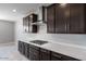 Modern kitchen featuring stylish cabinets, stainless steel range hood, and counter tops at 12219 W Caraveo Pl, Peoria, AZ 85383
