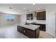 Well-lit kitchen with a large island, dark cabinets, stainless steel appliances, and a view of the backyard at 12219 W Caraveo Pl, Peoria, AZ 85383