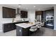 Modern kitchen features stainless steel appliances, dark wood cabinets and island with white quartz countertops at 12219 W Caraveo Pl, Peoria, AZ 85383