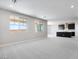 Open-concept living room with neutral carpet, large windows, and view of the kitchen at 12219 W Caraveo Pl, Peoria, AZ 85383