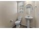 Cozy half bathroom featuring a pedestal sink, round mirror, toilet, and window with blinds at 13110 W Avenida Del Rey --, Peoria, AZ 85383