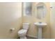 Clean half-bathroom with a toilet, pedestal sink, modern fixtures, and a large mirror with natural light from the window at 13110 W Avenida Del Rey --, Peoria, AZ 85383