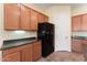 Clean kitchen boasts wood cabinets and black appliances and a large pantry at 13110 W Avenida Del Rey --, Peoria, AZ 85383