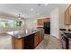 Spacious kitchen featuring a large island with sink and dishwasher, wood cabinets, and black appliances at 13110 W Avenida Del Rey --, Peoria, AZ 85383