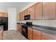 Modern kitchen with wood cabinets, black appliances, and tile flooring at 13110 W Avenida Del Rey --, Peoria, AZ 85383