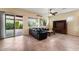 Comfortable living room with a black leather sofa, tiled floors, large windows, and a ceiling fan for added comfort at 13110 W Avenida Del Rey --, Peoria, AZ 85383