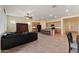 Expansive living room showing tile floors, a large black sofa, kitchen bar seating, and built-in entertainment center at 13110 W Avenida Del Rey --, Peoria, AZ 85383