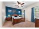 Comfortable main bedroom features a dark accent wall, wood furnishings, a ceiling fan, and windows for natural light at 13110 W Avenida Del Rey --, Peoria, AZ 85383