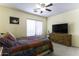 Bright bedroom with ceiling fan, dresser with a mounted TV, and a large window at 1325 E Brent Ct, Casa Grande, AZ 85122