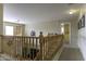 Hallway with wood banister overlooking living room area and sunny windows at 1325 E Brent Ct, Casa Grande, AZ 85122