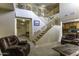 Comfortable living room features a staircase, neutral carpet, and leather seating for relaxation and gatherings at 1325 E Brent Ct, Casa Grande, AZ 85122